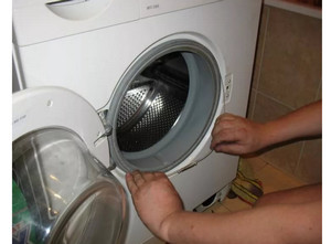 Мастер заменяет манжету люка в стиральной машины LG