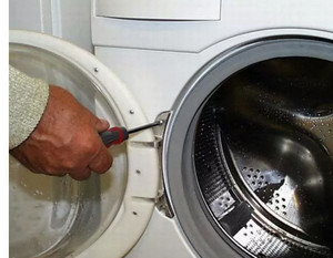 Мастер чинит люк стиральной машины zanuss